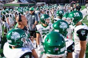 Sideline huddle with the team packed together